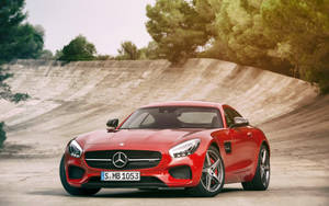 紅色 Mercedes-AMG GT 跑車停在彎曲的混凝土坡道上，背景有樹木。 — Mercedes Benz C300 壁紙