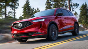 紅色Acura SUV在樹木成行的道路上快速行駛，動作模糊。 — Acura 壁紙