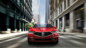 紅色豪華轎車在日落時分飛馳在現代城市街道上。 — Acura 壁紙