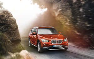 紅色BMW X1 SUV在森林中快速行駛，動作模糊。 — Mercedes Benz C300 壁紙