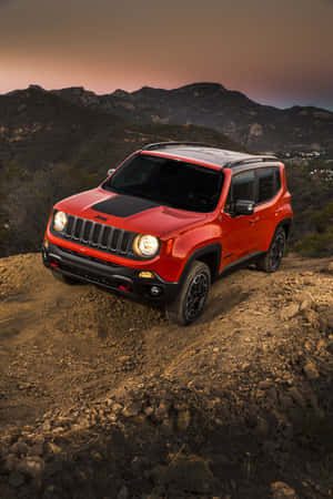 紅色Jeep Renegade在日落時分行駛於岩石山徑。 — POCO Pad 壁紙