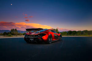 日落時分，紅色McLaren跑車停在瀝青路上，背景有山和月亮。 — 4K 法拉利 壁紙