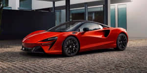 紅色McLaren跑車停在現代玻璃屋前的鵝卵石上。 — 麥拉倫 壁紙