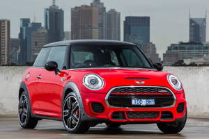 紅色MINI Cooper S停放在屋頂，俯瞰城市天際線。 — 酷車 壁紙