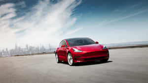 紅色Tesla Model 3在開闊的道路上行駛，背景是城市天際線。 — 特斯拉 壁紙