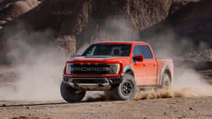 紅色福特 Raptor 卡車在沙漠地形中快速行駛，揚起灰塵。 — 福特 壁紙