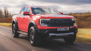 紅色福特 Ranger Raptor 皮卡在鄉村道路上疾馳。 — 福特 壁紙