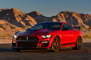 紅色Shelby GT500跑車停在沙漠公路上，遠山夕陽相伴。 — 山脈 壁紙