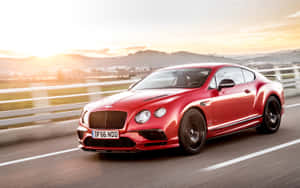 紅色賓利 Continental GT 在日落時分於高速公路上飛馳。 — 16:10 壁紙