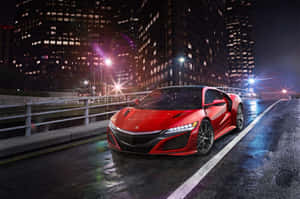 夜間濕滑城市街道上，紅色跑車伴隨著發光的燈光和高樓大廈。 — MacBook Air 13 壁紙