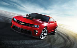 紅色雪佛蘭Camaro ZL1在藍天下沿著濕滑賽道疾馳。 — 好看汽車 壁紙