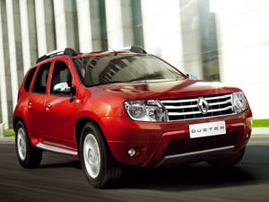 紅色雷諾 Duster SUV 駛過現代玻璃建築。 — 雷諾 壁紙