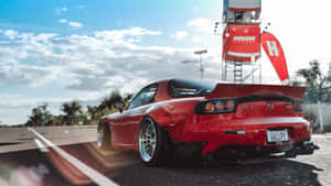 日落時分賽道上的紅色馬自達RX-7跑車。 — 馬自達 壁紙