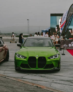 戶外車展中一輛亮綠色BMW M3，附近有參加者。 — Mercedes Benz C300 壁紙