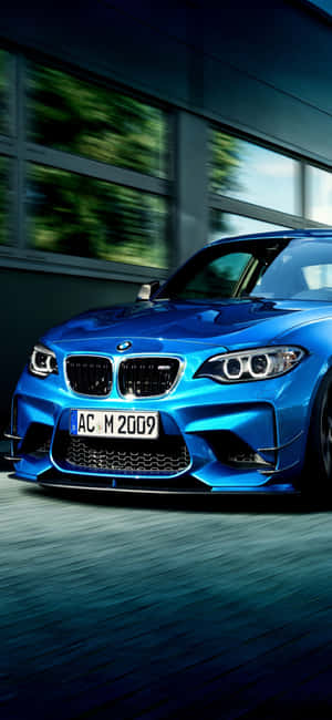藍色BMW M2以動態模糊效果高速駛過現代建築。 — Xiaomi 15 壁紙