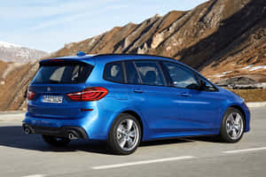 藍色BMW旅行車在積雪山頂的山路上行駛。 — Mercedes Benz C300 壁紙
