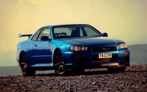 日落時分碎石路上的藍色日產Skyline GTR。 — 日產 Skyline GTR R34 壁紙