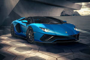 藍色藍寶堅尼 Aventador SVJ Roadster 停泊在混凝土結構下，後面有山脈。 — 跑車 壁紙