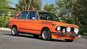 橙色Alpina BMW經典汽車在陽光明媚的日子停放在戶外。 — Mercedes Benz C300 壁紙