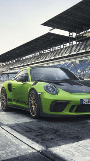 濕滑賽道上的青檸綠色保時捷911 GT3 RS與空看台。 — iPhone 11 Pro 壁紙