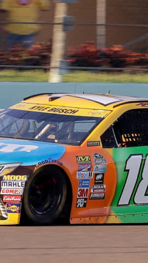 凱爾·布施色彩繽紛的NASCAR賽車在賽道上疾馳。 — iPhone 11 Pro 壁紙