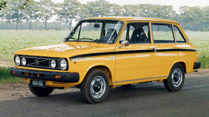 黃色復古Fiat 126p旅行車停泊在鄉村道路上，靠近一片綠色田野。 — Mercedes Benz C300 壁紙