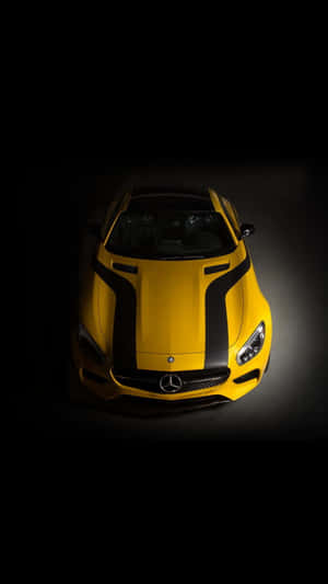 在黑暗工作室中照亮的黃色梅賽德斯-AMG GT 跑車，帶有黑色條紋。 — 漂亮鎖定螢幕 壁紙