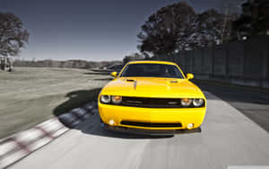 黃色 Dodge Challenger SRT 在賽道上高速行駛，帶有動態模糊效果。 — 道奇挑戰者 壁紙