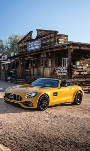 黃色敞篷跑車停在西部風格的麵包店前。 — Mercedes Amg iPhone 壁紙