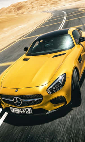 黃色 Mercedes 跑車在沙漠道路上飛馳，背景是沙丘。 — Tecno Megapad 壁紙