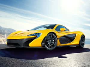 黃色McLaren P1超級跑車停放在海岸公路上，背景有山脈和城市。