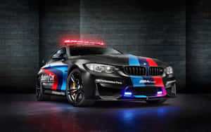 黑色BMW M4 Coupe安全車，帶有紅藍條紋，停在黑暗車庫中。 — MacBook Air M1 壁紙
