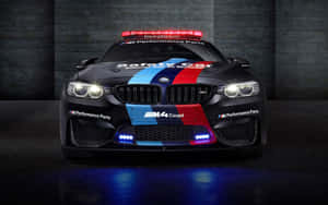 黑色BMW M4 Coupe安全車，帶有紅藍條紋和閃爍燈光，在黑暗車庫中。 — 動漫汽車 壁紙