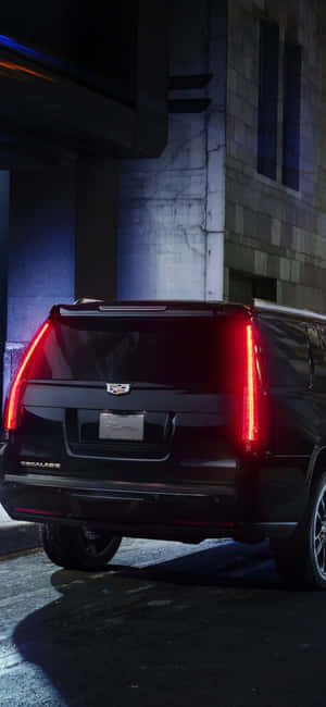 黑色Cadillac Escalade停在夜晚昏暗的城市小巷中。 — Xiaomi 壁紙