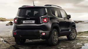 黑色Jeep Renegade SUV停泊在近海的岩石海灘上。 — 吉普 壁紙