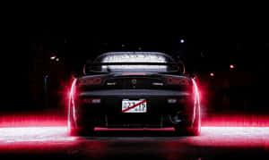 黑色Mazda RX-7跑車在潮濕夜街上發出紅色尾燈光芒。 — 馬自達 壁紙