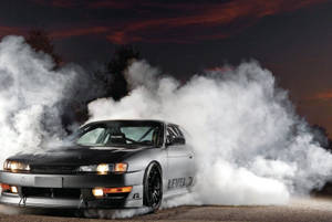 黑色和銀色跑車夜間飄移，帶有煙霧和橙色天空 — 日產 Skyline GTR R34 壁紙