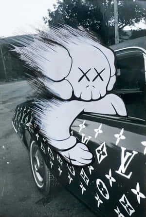 一輛黑色復古汽車，帶有白色路易威登圖案和卡通骷髏塗鴉設計。 — 淺棕色美學動圖 壁紙