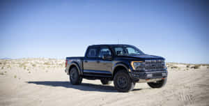 黑色福特 F-150 Raptor 在黃昏時停泊在沙漠小徑上。 — 福特 壁紙