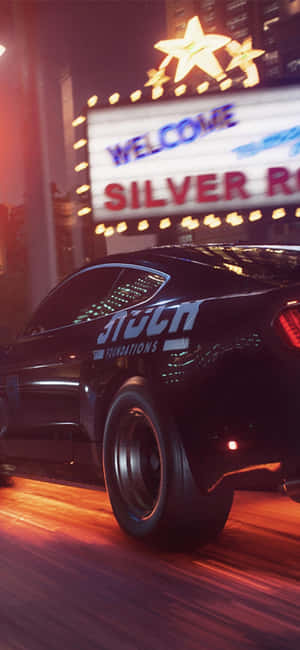 黑色賽車在夜間疾馳而過霓虹燈照亮的賭場標誌。 — 電玩遊戲 GIF 壁紙