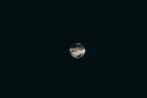 在黑暗的夜空中，月亮被雲層部分遮蓋。 — 月光 壁紙
