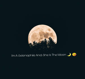 滿月在樹木剪影後升起，帶有文字「I'm A Selenophile And, She Is The Moon」和表情符號。 — 美學月亮 壁紙