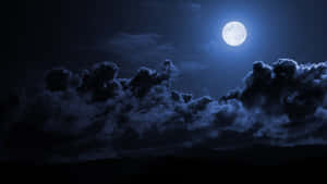 滿月穿過烏雲照耀著夜晚的山巒輪廓。 — 月夜星空 壁紙