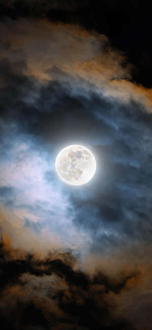 滿月在夜間穿過戲劇性的雲層閃耀。 — 月光 壁紙
