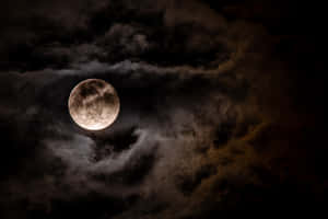 滿月在夜間穿過黑暗的暴風雲照耀。 — 月光 壁紙