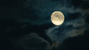 滿月穿過夜間的烏雲閃耀 — 美麗的滿月 壁紙