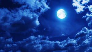 滿月在夜間透過深藍色雲層閃耀。 — 月光 壁紙