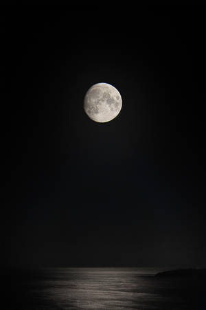 滿月映照在平靜的海洋上，夜空黑暗 — 暮光 壁紙