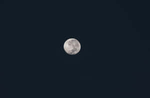 滿月位於沒有雲或星星的黑暗夜空中央。 — 月光 壁紙