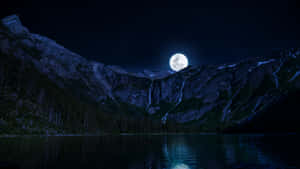 滿月映照在積雪的山峰上，倒映在夜晚平靜的湖面上。 — 月光 壁紙